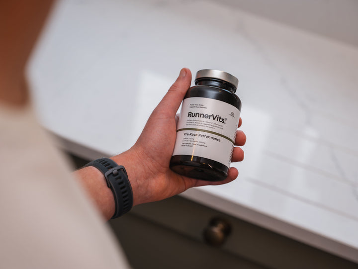 Runner holding a RunnerVits bottle in a kitchen